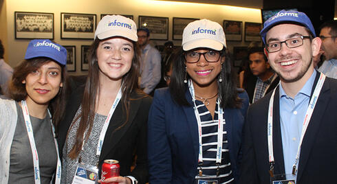 Four meeting attendees wearing INFORMS baseball caps at the 2017 Annual Meeting General Reception.